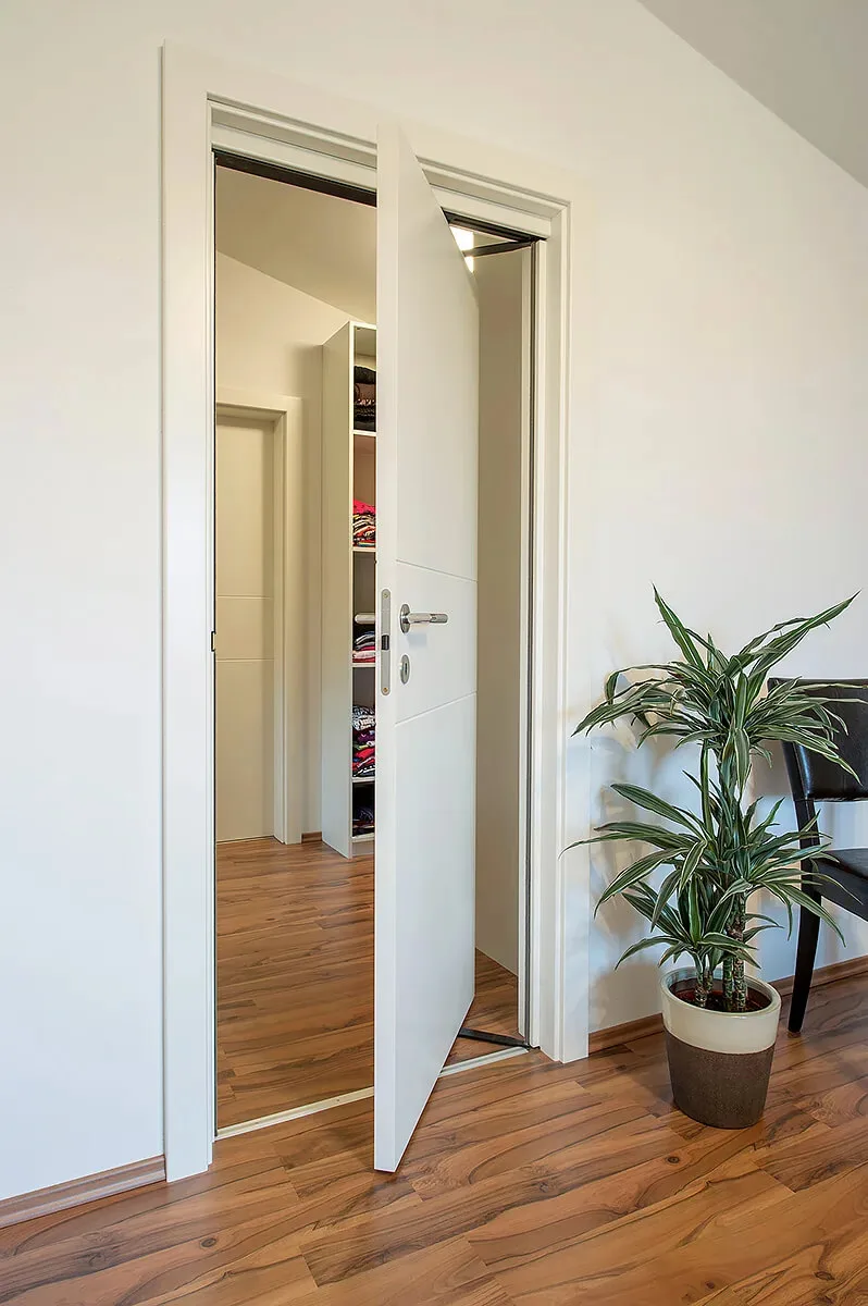 Ușă de interior albă deschisă către un dressing